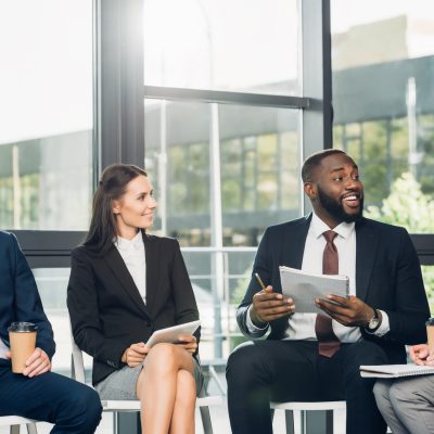 smiling multicultural businesspeople having meeting in conference hall