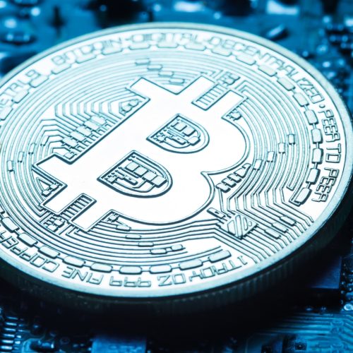 Virtual currency is the golden bitcoin on the background of the printed circuit board. Toning. The concept of virtual money and crypto currency.